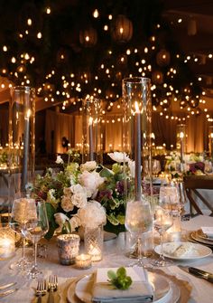 the table is set with candles, plates and silverware for an elegant wedding reception