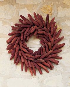 a wreath made out of red beans on a stone wall