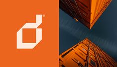 two tall orange buildings with the letter o on them and an orange box below it