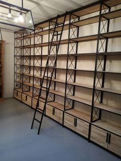 an empty room with shelves and ladders in it