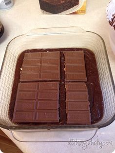 there are four pieces of chocolate cake in the pan on the kitchen counter next to cupcakes