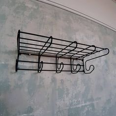 a metal rack with three umbrellas hanging from it's sides on the wall