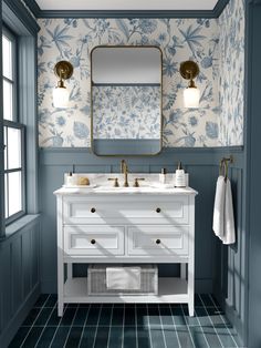 a bathroom with blue walls and white furniture