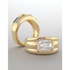 two gold wedding rings with an emerald cut diamond