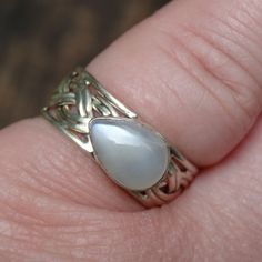 Handmade, Natural Sri Lankan Moonstone Sterling Silver Ring Size 7.5 Featured in this listing is a sterling silver, handmade, natural stone ring. This lovely ring features a beautiful, Natural Sri Lankan Moonstone in a teardrop shape, set east to west, and is 7x10mm. This beautiful Moonstone has beautiful white glow, the band is wide at 9mm, and features a rope design. This handcrafted ring is all set by hand, and into .925 Sterling Silver. Gemstone: Natural Sri Lankan Moonstone (7x10mm) Ring Si Handmade Silver Opal Teardrop Ring, Handmade Silver Teardrop Opal Ring, Silver Teardrop Moonstone Ring, Silver Teardrop Moonstone Ring For Anniversary, Untreated Silver Bohemian Moonstone Ring, Handmade Silver Teardrop Moonstone Ring, Untreated Sterling Silver Moonstone Ring For Anniversary, Handmade Silver Chalcedony Moonstone Ring, Adjustable Silver Moonstone Ring Hallmarked