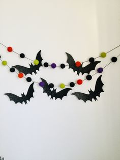 bats and pom - poms are hanging from a string on a white wall