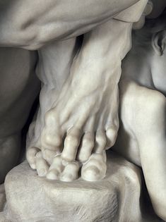 two hands touching the foot of a statue