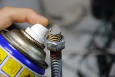 a person is holding a wrench and fixing an oil can