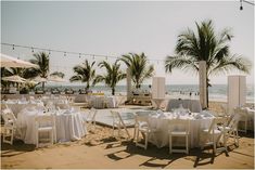 tables and chairs set up on the beach with palm trees in the background at a wedding reception