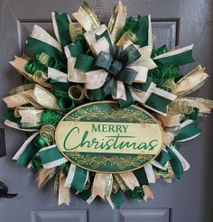 a green and gold christmas wreath with merry christmas written on it