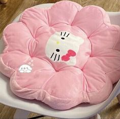 a pink hello kitty seat cushion sitting on top of a white chair