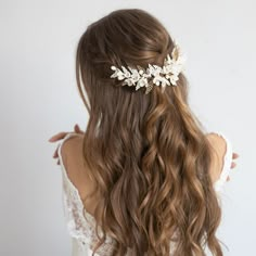 a woman with long hair wearing a white flower headpiece