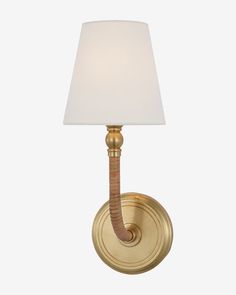 a wall light with a white shade on it's side and a gold finish