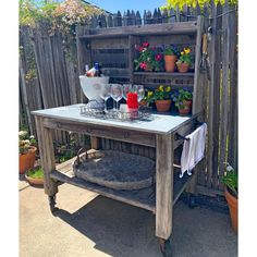 an outdoor table with wine glasses and bottles on it