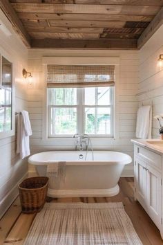 a bathroom with a tub, sink and rug in it's centerpieces