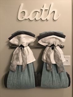 two towels hanging on a towel rack with the word bath written above them in white letters