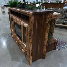 a wooden table sitting in the middle of a room with furniture on display behind it