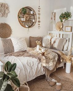 a bed with pillows and blankets on top of it in a room filled with plants