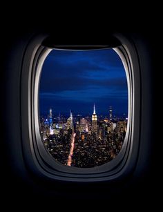 an airplane window with the view of new york city at night from it's seat