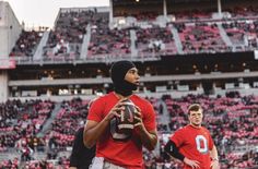 a man holding a football in front of a crowd