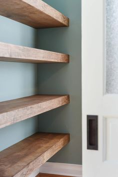 the corner shelves in this room are made out of wood and have been painted blue