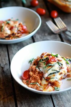 two white bowls filled with food on top of a wooden table