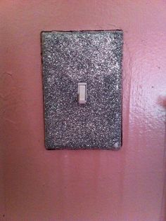 a pink wall with a silver light switch on it