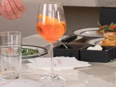 a table topped with plates and glasses filled with food next to wine glasses on top of each other