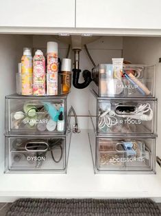 an organized bathroom cabinet with clear drawers and labels on the bottom, along with toiletries