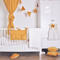 a white crib with yellow pillows and decorations