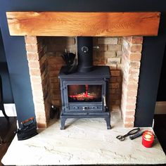 a wood burning stove sitting inside of a living room next to a red fire hydrant