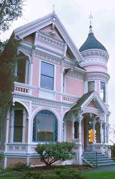 an old victorian house with pink paint and white trim