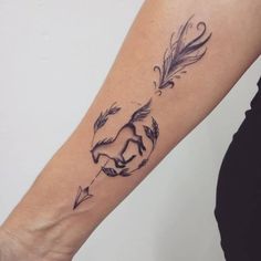 a woman's arm with a tattoo on it and an arrow in the middle