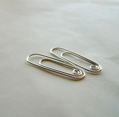 two pairs of scissors sitting on top of a white sheet with silver colored metal handles