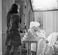 the woman is getting ready to cut the cake in her wedding dress while another lady looks on