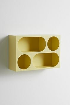 a yellow shelf with three holes in it