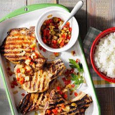 grilled chicken, rice and vegetables on a tray next to a bowl of salsa