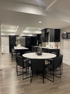 a kitchen with black cabinets and white counter tops is seen in this image from the dining room