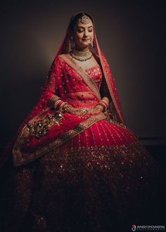 a woman in a red and gold bridal gown