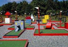 an artificial miniature golf course in the middle of a park with lots of play equipment