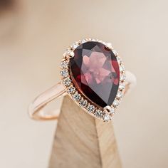 a ring with a large red stone surrounded by small white and brown diamonds on top