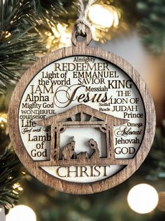 a christmas ornament hanging from a tree with the names of jesus and baby jesus