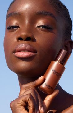 What it is: A 24-hour wear, liquid-to-powder foundation with medium coverage and a no-transfer formula to create a beautiful healthy glow and matte finish.Who it's for: Ideal for combination skin types.What it does: The liquid-to-powder foundation is born from Guerlain's bronzing powder expertise. It combines the seamless, ultrasensory lightness of a powder with the perfecting power of a fluid foundation to create an effortless finish. Terracotta Le Teint comes in a wide array of shades and unde Beauty Cosmetics Photography Model, Half Makeup Half No Makeup, Foundation Product Shoot, Skincare Beauty Photography, Makeup Products Photoshoot, Dark Skin Makeup Natural Simple, Terracotta Makeup, Skin Photoshoot, Makeup Job