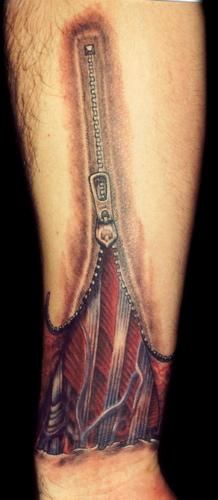 a man's arm with a tattoo on it that has a zipper attached to it