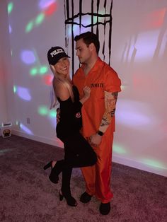 a man and woman dressed up in orange prison uniforms posing for the camera with their arms around each other