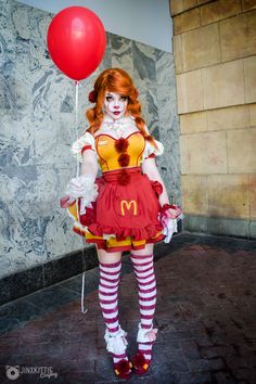 a woman dressed as a mcdonald's girl holding a red balloon in her hand