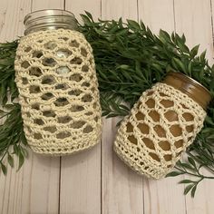 two crocheted mason jars sitting next to each other