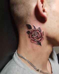 a man's neck with a rose tattoo on the side of his neck and behind his ear