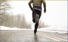 a man running down the road in the snow with his feet on the ground,