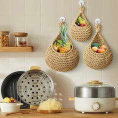 three baskets hanging on the wall above a counter with food and utensils in it